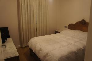 a bedroom with a large white bed and a window at Apartamento La Paz de Versalles in Avilés