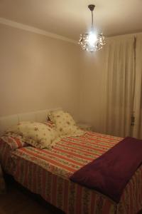 1 dormitorio con cama y lámpara de araña en Apartamento La Paz de Versalles, en Avilés