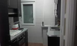 a small kitchen with a sink and a stove at Apartamento La Paz de Versalles in Avilés