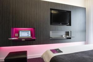 a room with a laptop and a tv on a wall at Akena Nantes Atlantis Zénith in Saint-Herblain