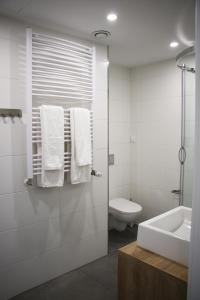 uma casa de banho branca com um lavatório e um WC em Lemon Plaza Hotel em Poznań