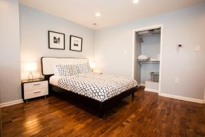 a bedroom with a bed and a wooden floor at Lawrenceville Suites in Pittsburgh