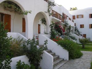 a building with white walls and stairs with flowers at Eri Hotel in Parikia