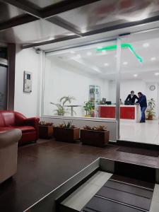 two people are standing in a room with a lobby at A Bogota On Holidays by Open - HOTEL in Bogotá