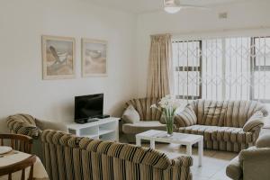 a living room with two couches and a tv at Shelly Beach, Villa Albatross 2 in Shelly Beach