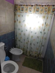 un bagno con un water e una tenda da doccia di Nicolas Nancy Ricardo a Las Grutas Altre 21 foto