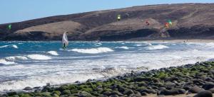 a person on a surfboard in the ocean with kites at Vacacional Tegueste 1ºA in Vecindario