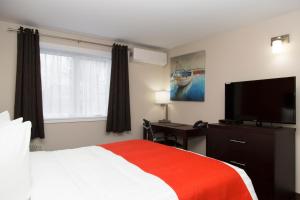 a bedroom with a bed and a flat screen tv at Hotel Robin Hood in Grand Falls -Windsor