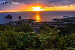 a sunset over the ocean with the sun setting at Casa Dos Mosteiros in Mosteiros