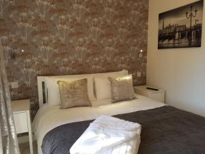 a bedroom with a white bed with a floral wallpaper at Sweet Suites Residence in Lytham St Annes