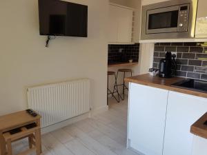 a kitchen with white cabinets and a microwave at Sweet Suites Residence in Lytham St Annes