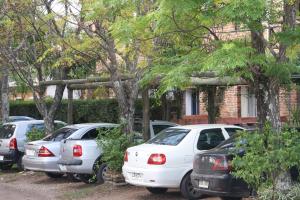 a row of parked cars in front of a house at Hotel Village Termas de Dayman in Termas del Daymán
