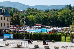 a resort with a swimming pool and people on scooters at Стаи за гости Ве-Бо-Ли** in Bankya