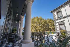 une terrasse couverte avec une colonne et des chaises sur un balcon dans l'établissement Demeure Terrisse La Résidence, à Marseillan