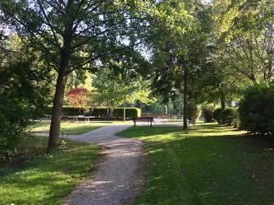 a path in a park with a bench and trees at Gästehaus Linde in Endingen