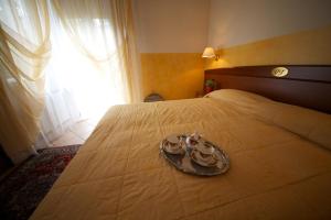 Una cama con una bandeja con dos platos. en Villa Terri, en Verona