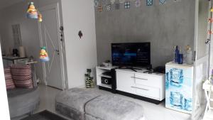 a living room with a television and a couch at Pitangueiras 3 suítes com vista para o mar in Guarujá