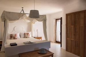a bedroom with a white bed with a canopy at La Peschiera in Monopoli +37 photos