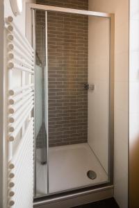 eine Dusche mit Glastür im Bad in der Unterkunft Le Café-Hôtel de L'Aubier in Neuenburg