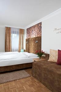 una camera con un grande letto e un divano di Biergasthof Riedberg a Ried im Innkreis