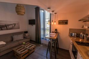 a living room with a couch and a table at Demeure Terrisse Les Studios in Marseillan