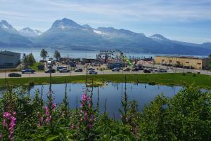 uma vista para uma cidade e um parque de estacionamento com montanhas em Keystone Hotel em Valdez