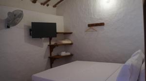 バリチャラにあるMONCOGUA Casa de Hospedajeの壁にテレビとベッドが備わる客室です。