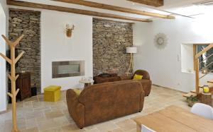 a living room with two couches and a stone wall at Gites Domaine du Charouzech in Salles-Curan