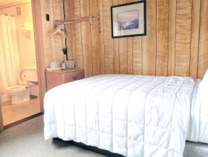 a bedroom with a bed and a bathroom with a toilet at Keystone Hotel in Valdez