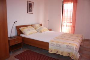 a bedroom with a bed and a window at Budget Apartments Batkoski Pag in Pag