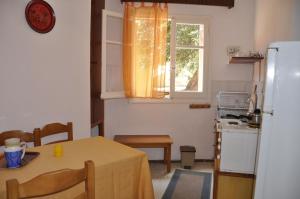 a small kitchen with a table and a refrigerator at Molos Beach Apartments in Paleokastritsa