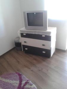 - une télévision assise sur une commode dans une pièce dans l'établissement Villa ALEX, à Slatina