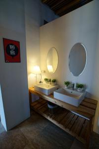 a bathroom with two sinks and two mirrors at Time Travel B&B in Taitung City
