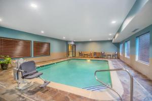 una piscina en una habitación de hotel con una silla en Holiday Inn Express Hotel Howe / Sturgis, an IHG Hotel, en Howe