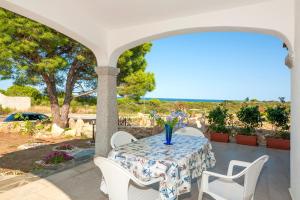 einen Tisch mit einer Vase auf einer Terrasse in der Unterkunft Sant'Anna Charming Apartments in Budoni