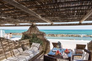 a patio with a table and chairs and the ocean at La Peschiera in Monopoli