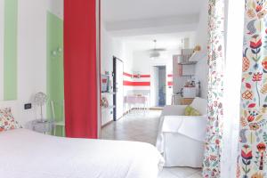 una camera con un letto bianco e una parete rossa e verde di Peaceful apartment in the heart of Bologna a Bologna