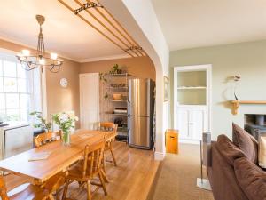 una cucina e una sala da pranzo con tavolo e frigorifero di River Cottage a Inverness
