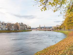 una vista di un fiume in una città con edifici di River Cottage a Inverness
