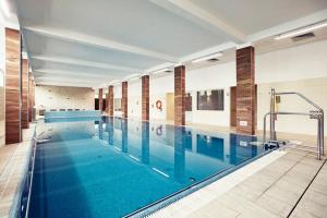 a large swimming pool with blue water in a building at Instytut Zdrowia Sofra im Ewy i Sobiesława Zasady ul Polna 4 in Karpacz