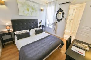 a bedroom with a large bed and a mirror at Hôtel Le Mistral in Marseille