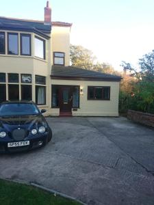 a black car parked in front of a house at Sweet Suites Residence in Lytham St Annes
