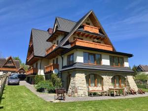 une grande maison avec un toit en gambrel dans l'établissement Willa Wisienka, à Zakopane