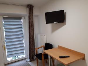 a room with a table and a television on the wall at Super schöne Fewo in Aalen