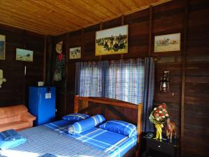 ein Schlafzimmer mit einem Bett mit blauen Kissen in der Unterkunft Stonewood Cowboy City Resort in Ban Krok Duan Ha