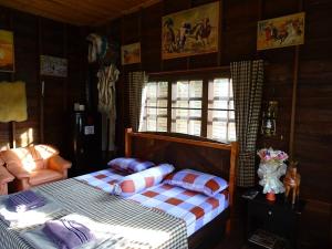 ein Schlafzimmer mit 2 Betten und einem Stuhl darin in der Unterkunft Stonewood Cowboy City Resort in Ban Krok Duan Ha