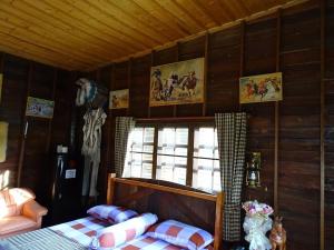 Schlafzimmer mit einem Bett und einer Wand mit Bildern in der Unterkunft Stonewood Cowboy City Resort in Ban Krok Duan Ha + 34 Fotos
