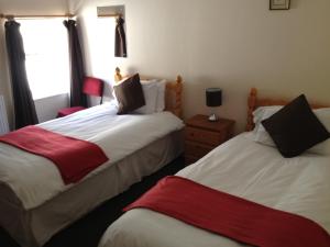 a bedroom with two beds and two nightstands at Drovers Arms Hotel in Carmarthen