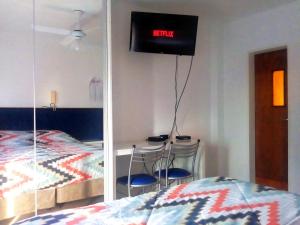 1 dormitorio con 1 cama y TV en la pared en Uni Medicina en Rosario