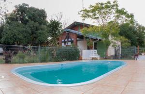 a swimming pool in front of a house at Cabañas Mama Rosa in Puerto Iguazú